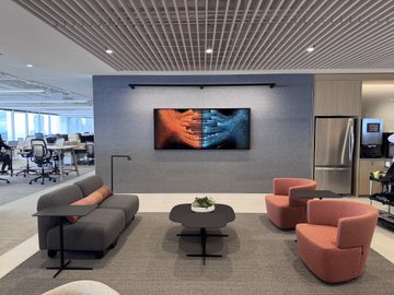 The Long Becoming displayed as a wide framed print in a NORC office lounge